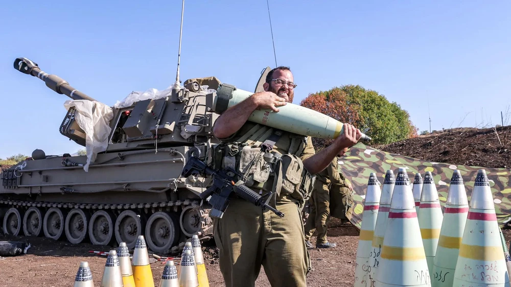 Một người lính Israel di chuyển một quả đạn pháo 155mm vào tháng 10-2023. Ảnh: AFP 1697736410060.jpg