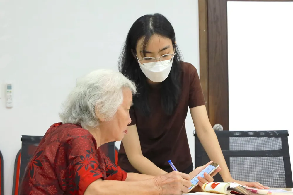 Các bạn tình nguyện viên hướng dẫn tận tình cho cô chú, người lớn tuổi. Ảnh: DI LINH. Người trẻ tại TPHCM dạy công nghệ, AI miễn phí cho người lớn tuổi