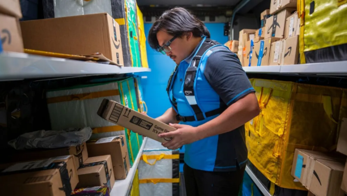 Một tài xế giao hàng đang cầm một gói hàng trong khi đeo kính thông minh của Amazon. Kính hiển thị hướng dẫn và hướng dẫn giao hàng theo thời gian thực. Ảnh: Amazon